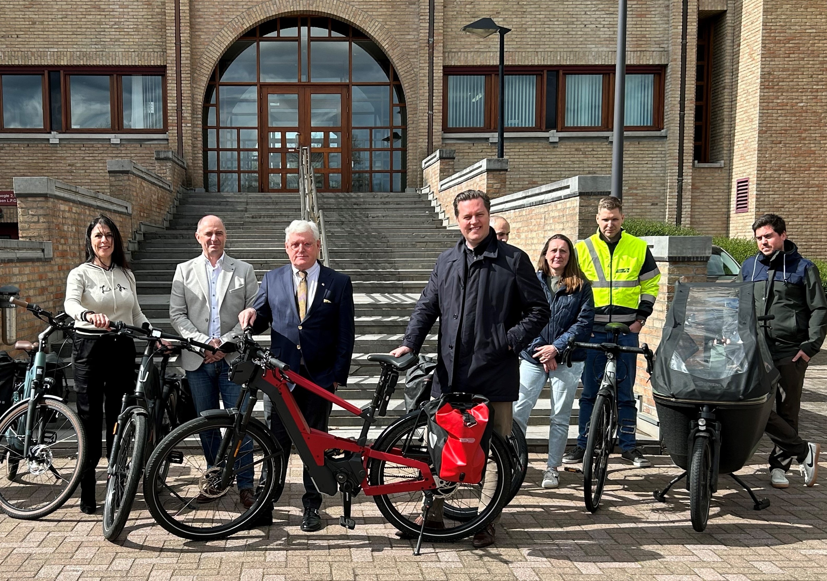 groepsfoto van gedeputeerde Bert Lambrechts en Tom Vandeput samen met werknemers van de provincie bij hun fiets