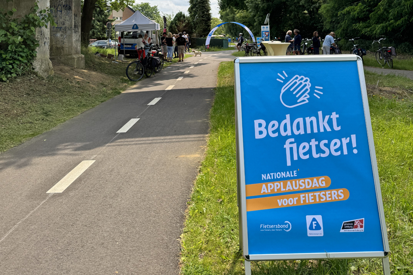 Bord met "Bedankt fietser", in de achtergrond het tentje en de ijskar