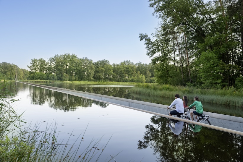 Mensen fietsen door het water bij daglicht